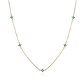 Macro di una collana dorata con cinque ciondoli a fiore in gemme verdi su fondo bianco - Collana Quadrifoglio Zirconia Verde Oro