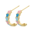 Détail de boucles d'oreilles en C dorées avec des étoiles en émail rose et bleu - Motif Étoile à Cinq Branches