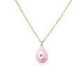 Detailed macro view of pink enamel evil eye water drop pendant on a gold O-chain necklace - Pink