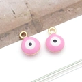 Detailed macro view of two pink evil eye round pendants with golden plated alloy frames - Small Round / Pink