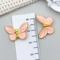 Nahaufnahme von rosa Schmetterlingsanhänger mit Goldrand und Messskala - Pink Emaille Gold Schmetterling