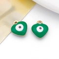 Macro shot of two green enamel heart charms with evil eye design for DIY jewelry - Heart / Green
