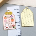 Close-up of Omamori metal charms with enamel floral patterns and ruler measurement - Pink Chinese Style Good Fortune Charm (23212)