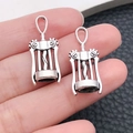 Macro detail of two antique silver alloy corkscrew pendants held on a finger for scale - Wine Corkscrew Style / Antique Silver (10558)