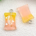 Macro shot of orange gradient resin candy pendants with Sweet text and silver loops - Yellow Pink Gradient Resin Candy (17116)