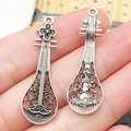 Gedetailleerde macro-opname van vintage zilveren luit-bedeltjes met holle patronen en texturen - 36x12mm Antiek Zilveren Pipa