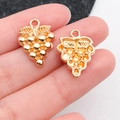 Pair of vintage golden grape charms showing front and back details on fingers - Fruit Wine Style (20820)