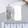 Detailed macro view of a silver-tone keyboard charm showing front keys and smooth back - Mouse Keyboard Accessory Style (21451)