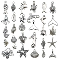 Flat lay of antique silver ocean charms including starfish and shells for DIY jewelry making - 32Pcs Antique Silver Ocean Series