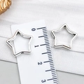 Nahaufnahme silberner hohler Sternperlen für DIY-Schmuck mit Maßstab auf Stoff - Hohl perforierter fünfzackiger Stern-Stil (23289) / 15x15mm