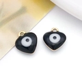 Detailed macro view of heart-shaped evil eye pendants with black enamel and gold plating - Heart / Black