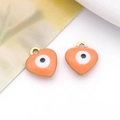Macro detail of two heart-shaped evil eye enamel charms with golden metal loops - Heart / Orange
