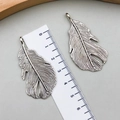 Detail view of vintage silver feather pendants showing 4.5cm length on a scale ruler - Antique Silver (B196)