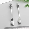 Detailed macro view of vintage silver fork pendant with ornate crown and cross relief - Crown Dinner Fork (18826)