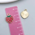 Detail of red strawberry alloy pendant showing dimensions with a ruler and back texture - 1Pc KC Gold Red Enamel Strawberry (23390)