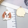 Vue détaillée des pendentifs chien montrant la finition émail et le dos en métal brossé - Cavalier Tacheté (23308)
