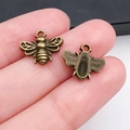 Gros plan détaillé de breloques abeilles en alliage doré antique montrant la texture des ailes - Forme d'Abeille 13x11mm (20149)