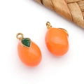 Vue macro de pendentifs orange en forme de fruit avec des crochets dorés - Pendentif Mangue 3D Orange Solide (T1604)