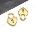 Détail macro de deux pendentifs en acier inoxydable doré en forme de cœur avec trou de serrure - Grand Cadenas Coeur Plat Doré(T2370)