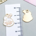 Detailed view of white enamel bunny pendants with size scale and metallic back texture - White Enamel Rabbit