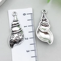 Detailed view of conch shell alloy pendant with swirl texture and ruler for scale - Large Conch Shape (22299)