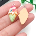 Close-up of DIY resin ice cream charm with pink cream, green cone, and metal loop - Yellow Base Green Bow (24503)