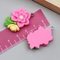 Pink resin flower charm for DIY jewelry with metal loop and ruler for size scale - Camellia (24349) / Rose Red