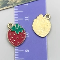 Red enamel strawberry alloy pendant charm with golden dots and a green leaf detail - Strawberry Style (24414)