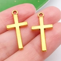 Pair of minimalist golden cross pendants held by fingers to show actual product scale - Cross Style (20374)