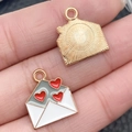 DIY jewelry charm showing a gold envelope pendant with red hearts held in fingers - 1 Piece Envelope Style (21526)