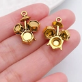 Goldene Schlagzeug Anhänger für DIY Armbänder auf Fingerspitzen zum Größenvergleich gezeigt - Schlagzeug-Stil