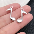 Silberne Musiknoten-Anhänger für DIY-Schmuck in der Hand zur Größendarstellung - Schlanke Musiknote (20913)