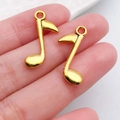 Goldene Musiknoten-Anhänger für DIY-Schmuck, zur Veranschaulichung der Größe in der Hand - Vertikaler Musiknoten Stil