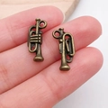 Pair of vintage bronze trumpet charms for DIY jewelry making held in hand for scale - Trumpet (20906)