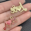 Handheld view of LOVE letter charms in gold texture and pink glitter enamel for DIY jewelry - Red Glitter LOVE (21458) / 18x27mm