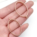 Goldene ovale Anhängerrahmen für DIY-Schmuckherstellung in der Hand auf weißem Grund - KC Gold Oval Stil