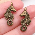 Pendentif hippocampe en alliage bronze antique tenu en main pour taille bijoux DIY - Style Hippocampe (20724)