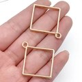 Zwei goldene quadratische Metallanhänger für DIY-Schmuck, präsentiert in der Hand - Klein KC Gold Quadrat Stil