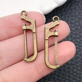 Hand holding two vintage bronze hacksaw charms for DIY jewelry making and crafts - Antique Bronze Saw (17389)