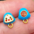 Vue macro d'un pendentif en émail bleu avec visage de poupée et caractère doré Fu - Zongzi Souriant Bleu Moyen (22616)