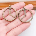 Steampunk gear clock charms in antique bronze finish held in hand for DIY jewelry projects - Round Hollow Clock Gear (1870)