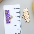 Vue détaillée du pendentif émaillé violet 2026 avec règle pour mesurer la taille - KC Or Violet 2026