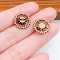 Steampunk bronze gear charms for DIY jewelry making held in hand for size visualization - Small Gear (8219)