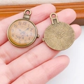 Detail of vintage bronze clock charms showing Roman numerals and floral relief back - Round Oil Drip Vintage Clock (17308)