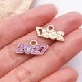 Macro de pendentifs dorés 2024 et 2027 avec émail violet et finitions métalliques texturées - Violet 2027