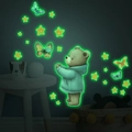 Dettaglio degli adesivi murali con orsetto e farfalle luminose che brillano al buio in verde - 30*40cm / Verde