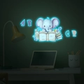 Sticker mural lumineux montrant un petit éléphant lisant des livres dans l'obscurité - Bleu / 30x30cm