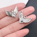 Silver winged heart pendant with clear zircon stone shown held by hand for size - Silver Tone White Zirconia (16389)