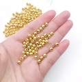 Golden round spacer beads in hand showing smooth finish for DIY jewelry making - Round Bead (15851)