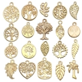 Flat lay of 19-piece golden Tree of Life and leaf alloy pendants for DIY jewelry making - Tree and Leaf Series (SN890) / 20 Pieces Set / KC Gold